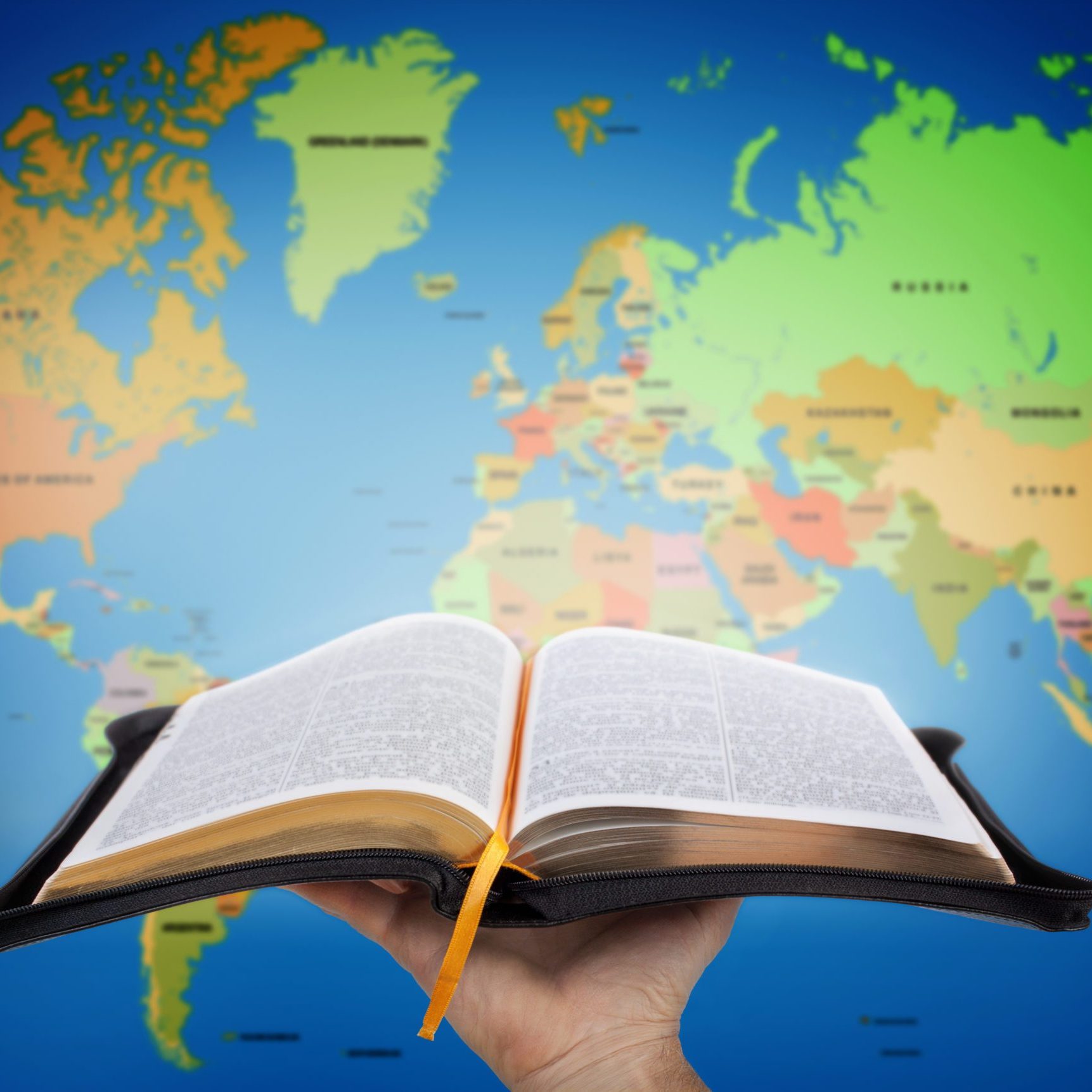 The Great Commission Hand showing the Holy Bible against world map